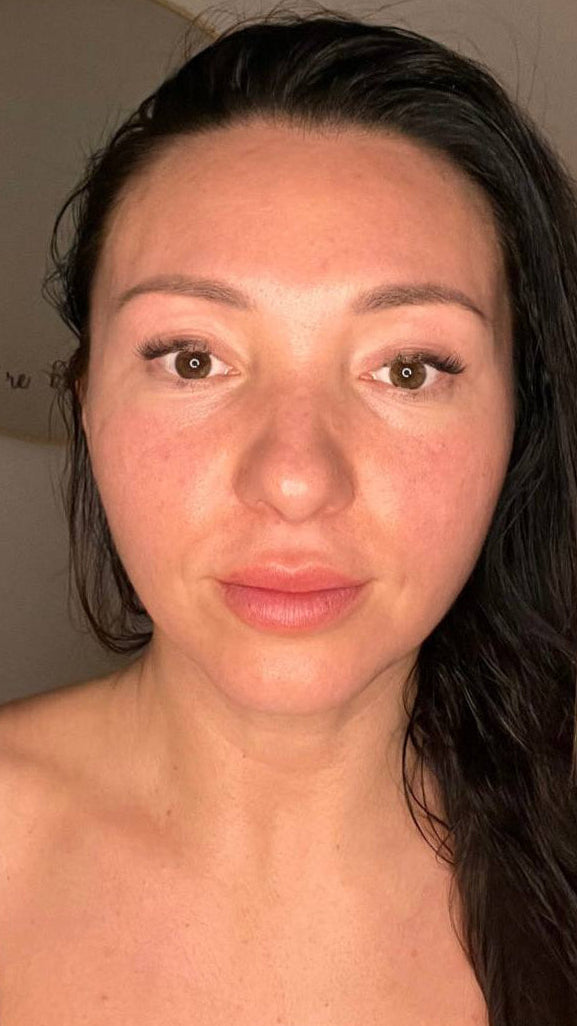 Close-up of a person with dark hair and fair skin against a neutral background, facebliss